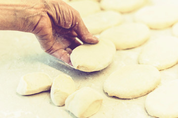 Woman hand making tasty fried patties or pies in kitchen.