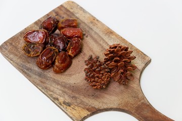 dates and pine cone on a wooden table