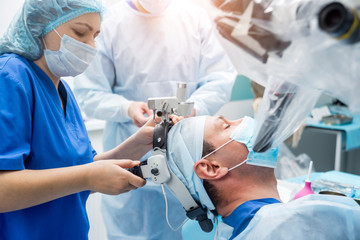 Naklejka na ściany i meble Brain surgery. Group of surgeons in operating room with surgery equipment.
