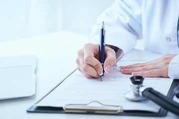 Female medicine doctor hand holding silver pen writing something on clipboard closeup.. Ward round, patient visit check, medical calculation and statistics concept. - obrazy, fototapety, plakaty