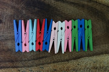 Colourful clothespins collection isolated on wooden background.