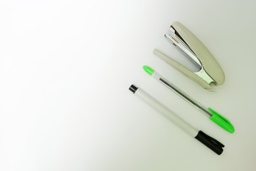 Traditional toy made from bamboo (klotokan/otok-otok), pens and stapler isolated on white background. Top view close up details.