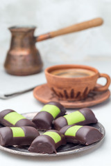 Swedish sweets punsch rolls or punschrullar, covered with green marzipan, on metall plate, served with coffee,  vertical