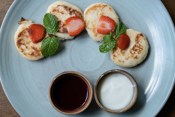 Cottage cheese pancakes with jam and sour cream. Russian syrniki or sirniki, cottage cheese fritters or pancakes served with jam and sour cream