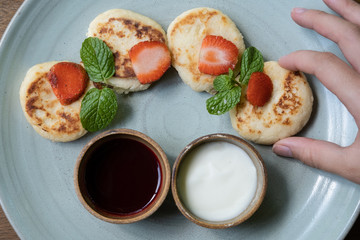 Cottage cheese pancakes with jam and sour cream. Russian syrniki or sirniki, cottage cheese fritters or pancakes served with jam and sour cream