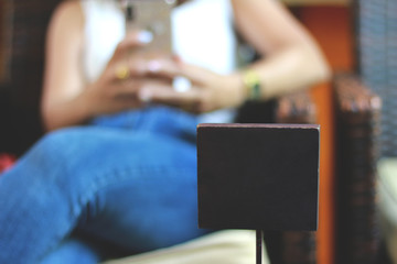 Blank Brown mini wood board. women sitting on sofa in cafe shop.