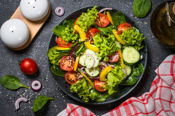 Fresh vegetables salad on black.