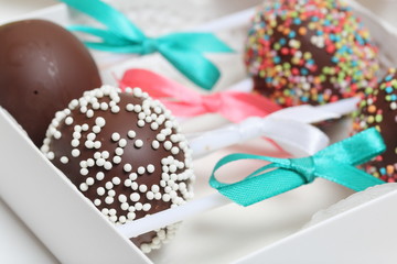 Cake pops decorated with a bow of braid, packed in a gift box.