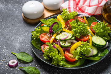 Fresh vegetables salad on black.