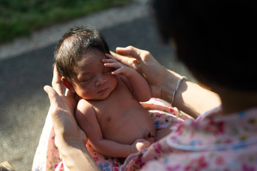 A portrait of a 42-day-old boy born in a lotus birth with her mother. Unlike babies in general, the baby's umbilical cord is left to join with the placenta until the rope is cut off by itself