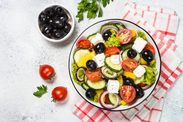 Greek salad in black plate on the table.
