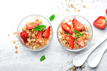 Tasty Strawberry Dessert, Homemade Yogurt with Strawberries, Granola and Chia Seeds over Bright Background
