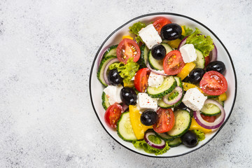 Greek salad in black plate on the table.