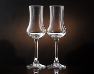 Two glasses of cognac sniffer on a colored dark background