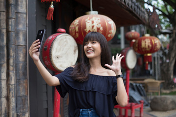 Fototapeta na wymiar young asian woman selfie with smart phone in China town