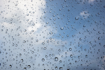 drop of water on window glass, cloud and blue sky background