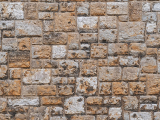 Old beige stone wall background texture close up. Texture of a stone wall. Old castle stone wall texture background. Stone wall as a background or texture. Part of a stone wall, for background.