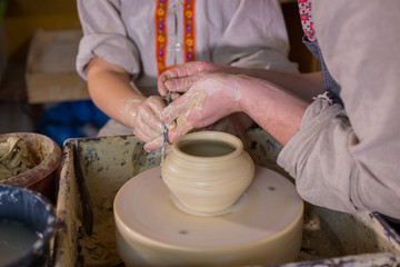 Potter showing how to work with ceramic in pottery studio