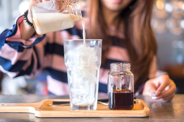 Thai Iced Tea and milk poured in a glass with ice