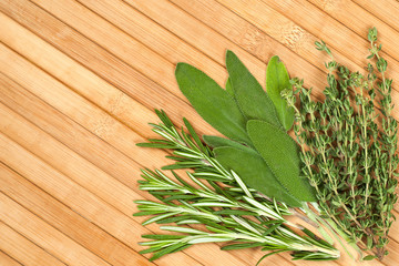 Collection of fresh herbs for cooking isolated on wooden background. Bunch of herbs