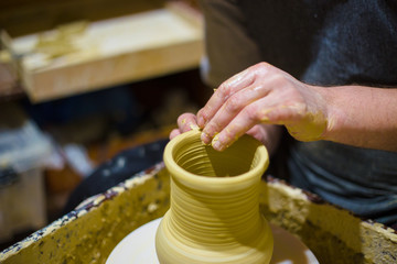 Professional male potter making jug in pottery workshop