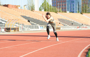 Fototapeta premium Beautiful athletic girl running around the stadium