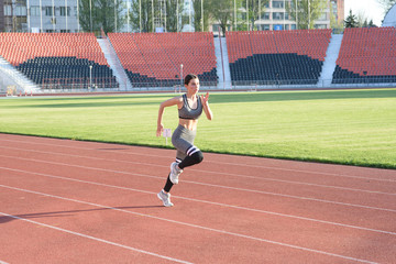 Fototapeta premium Piękna dziewczyna lekkoatletycznego biegania po stadionie