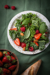 Vitamin salad with kale salad, basil, strawberry, raspberry and nuts
