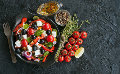 Greek salad with cucumber, tomato, pepper, salad, onion, feta cheese and olives seasoned with olive oil. The view from the top. Copy space.