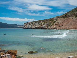 Some surfers in the beach of Buggerro in Sardinia
