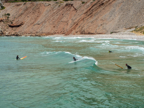 Some surfers in the beach of Buggerro in Sardinia