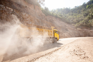 Dump truck driving on the mountain road at a construction site.