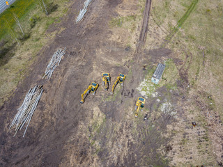 Aerial view of the four yellow crawler excavators that stand on the ground near the construction...