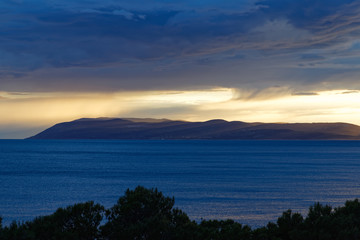 Stormclouds over a isle at sunset