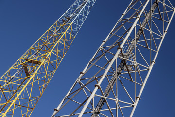 high voltage pylon against blue sky