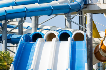 Steep water slides with pipes in water park.