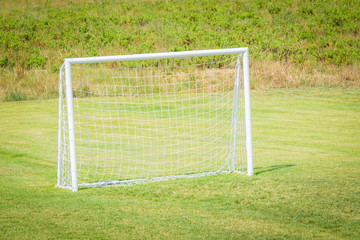 Fototapeta premium Football goal with net for playing on green grass.