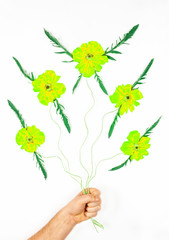 abstract composition with flying fantastic flower buds yellow green color with leaf wings on ropes held by a man hand on a white background, top view