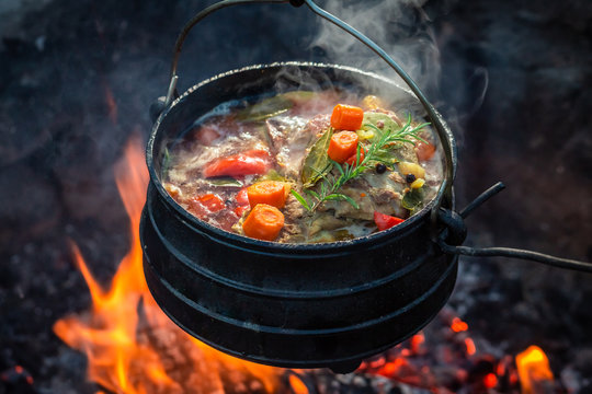Tasty and spicy hunter's stew on bonfire