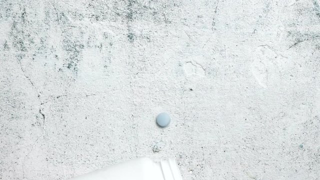 Blue Pills on concrete background. Slow mo 25%, 100 fps