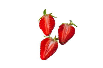 Three fresh juicy strawberries with leaves isolated on a white background, cut in half.