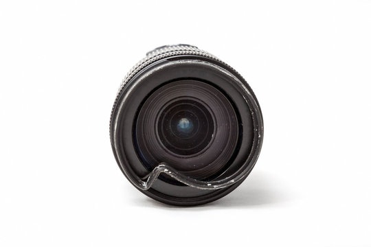 Damaged and broken zoom lens for the digital camera, dented protective UV filter. Front close up view To be repaired. Isolated on white background