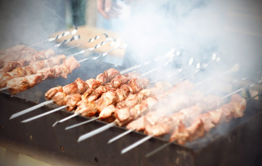 Delicious kebabs skewered on metal skewers and cooked on the grill in the summer outdoors