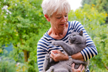 Frau schmust mit Katze auf dem Arm