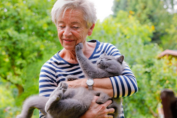 Frau schmust mit Katze auf dem Arm