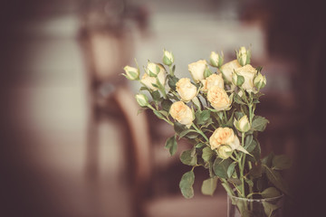 Bouquet of beautiful roses flowers on a blurred home background of dining room kitchen. Family holiday concept