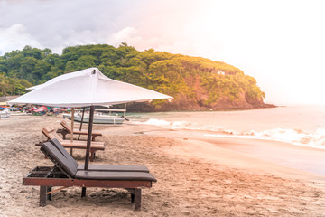 Empty sunbeds waiting for tourists on Virgin beach or Pasir Putih or Perasi Beach on Bali, Indonesia. Beautiful and clean tropical white sand beach