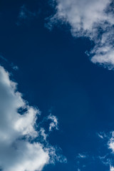 Negative Space with Puffy Cumulus Cloud On Vibrant, Deep Blue Sky