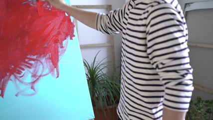 Man writes turquoise acrylic on canvas. Abstract acrylic figures and lines on art canvas. Artist at work. The artist paints a picture in the Studio. Creative process. - Powered by Adobe