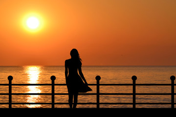 Woman silhouette enjoying sunrise